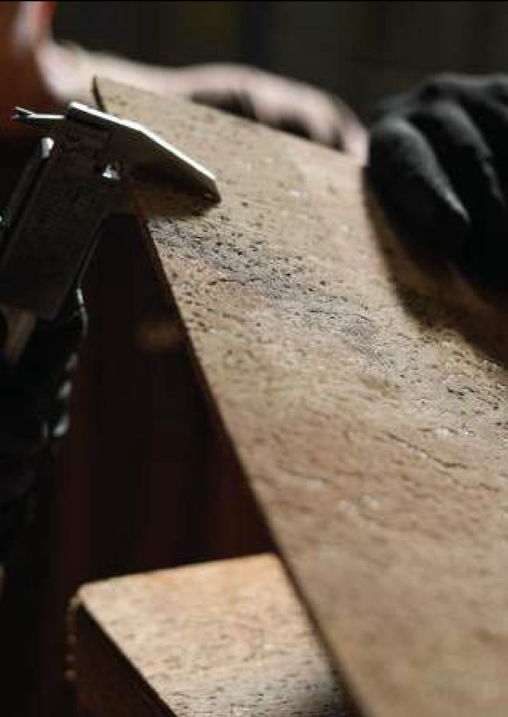 A cork tile being checked by hand